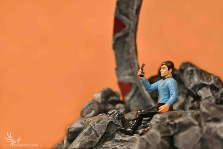 Leonard McCoy (star trek) sitting on steps in front of a stargate