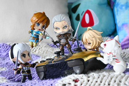 various video games characters (Geralt, Link, Amaterasu, Ada, Aether) fighting over a real life game controller.